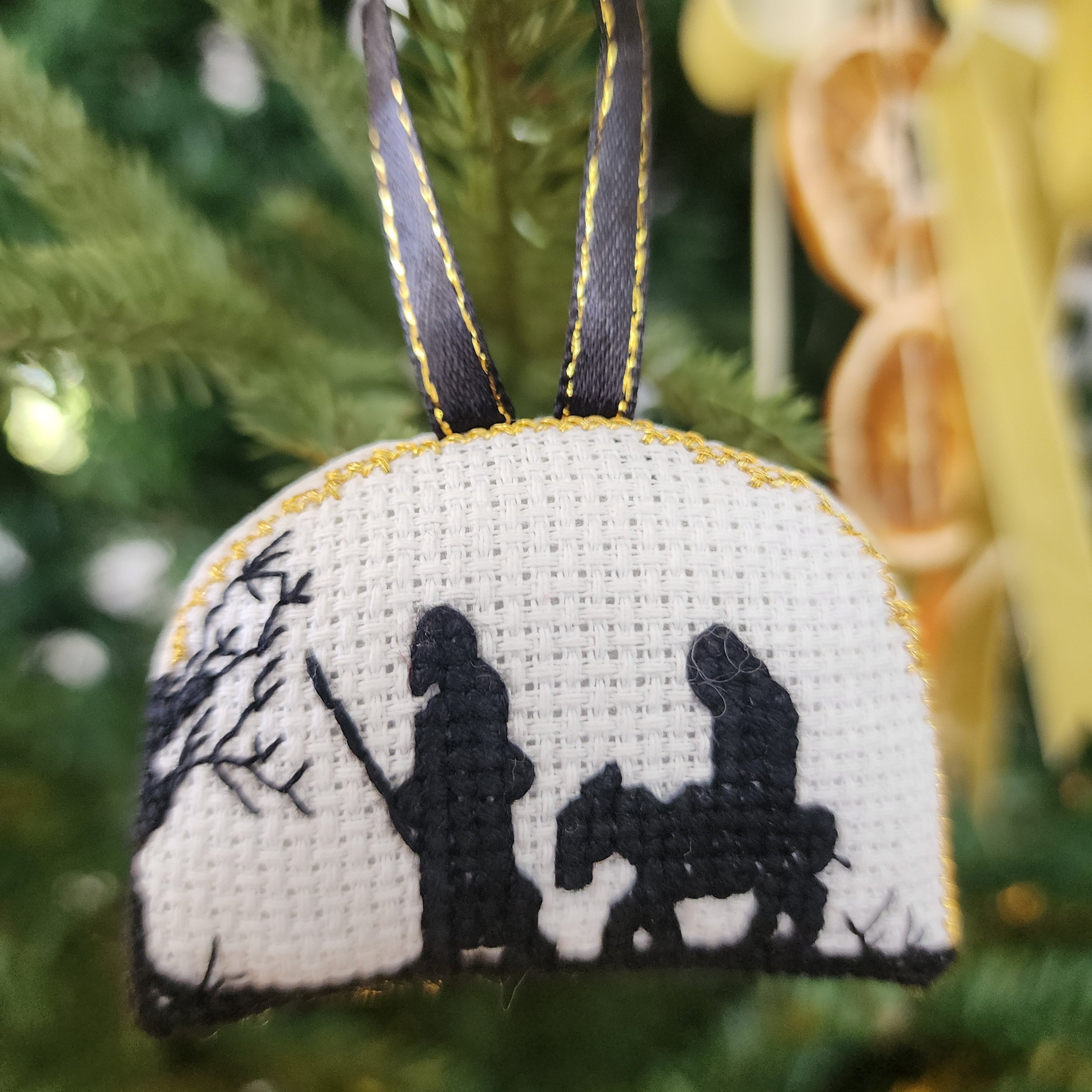 Decorative ornament with black and white design of Mary and Joseph 