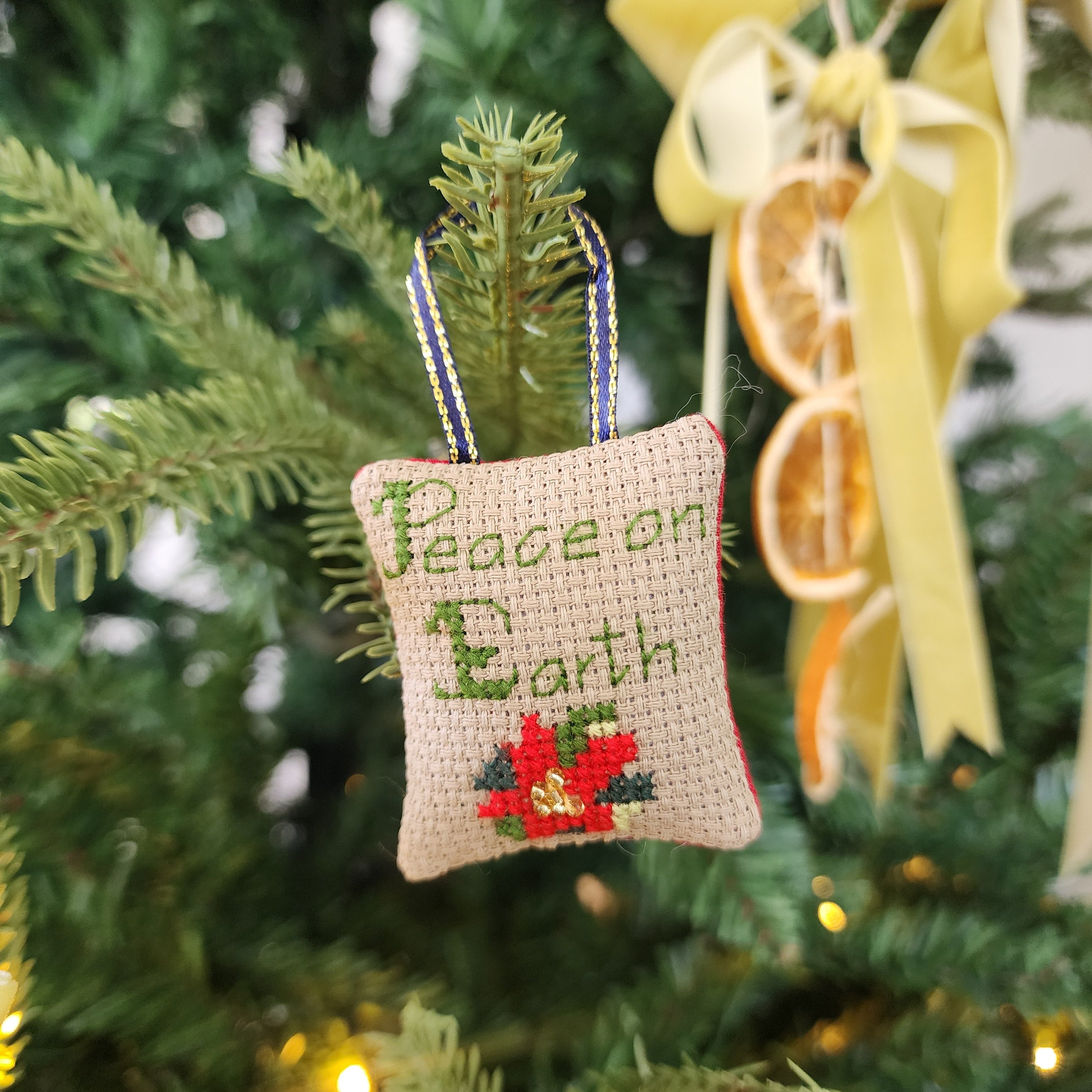 Decorative ornament with 'Peace on Earth' text on a Christmas tree.